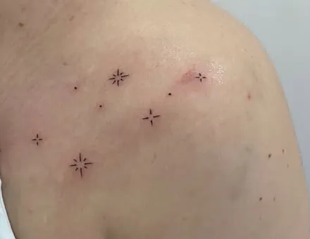 Estrellas de cuatro puntas en línea fina sobre el hombro
